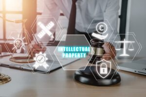 Intellectual property concept, Male judge working with laptop computer in courtroom with intellectual property icon on virtual screen.