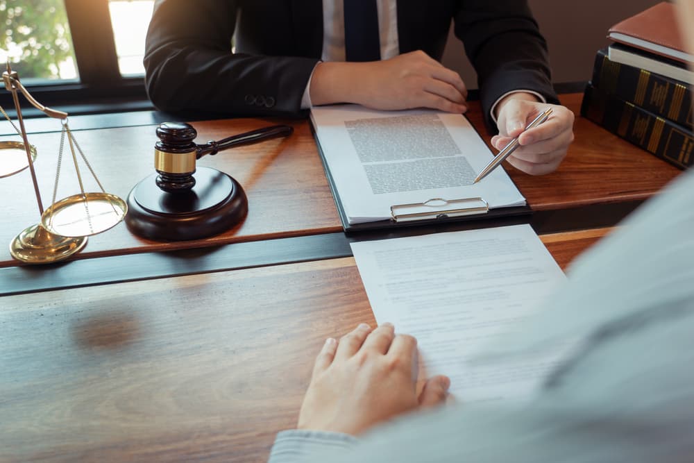 Male notary, lawyer, or judge consulting with a businessman client in an office, reviewing contract documents—representing the law and legal services concept.