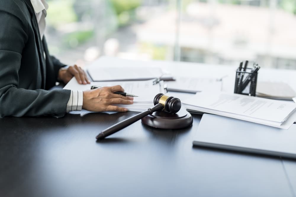 Lawyer working with law books in office or courtroom. Legal counsel with gavel on desk, representing justice and legal concepts.