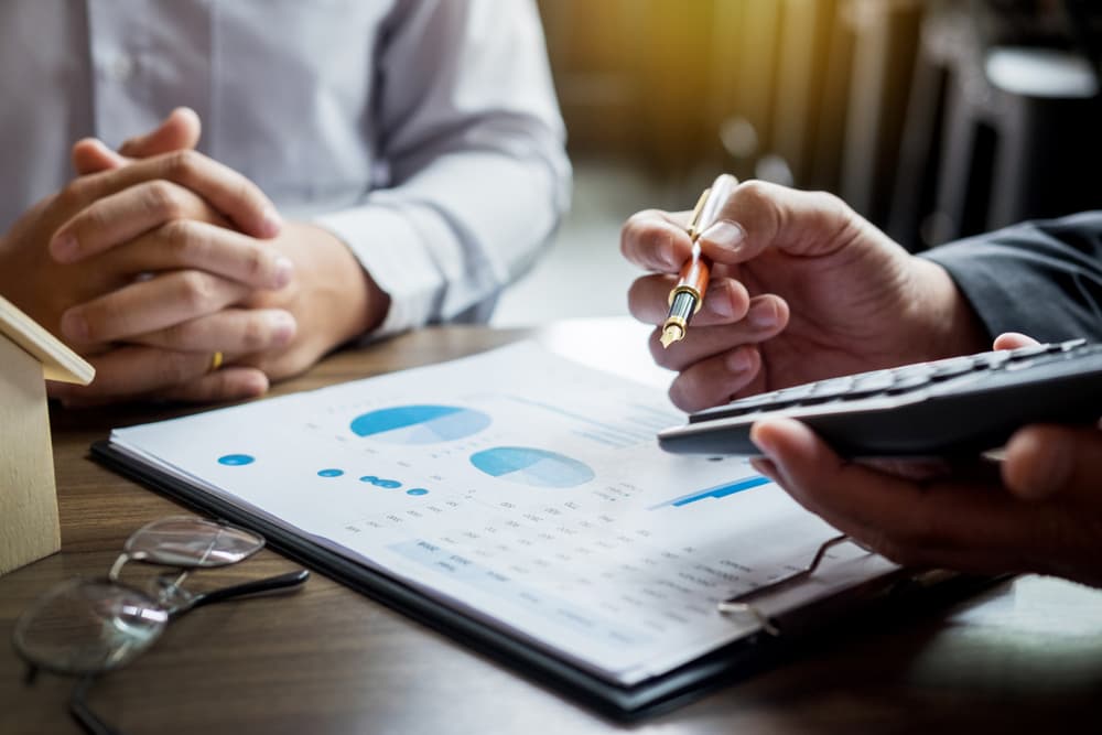 Two professionals review financial documents, symbolizing negotiation and dispute in The Tiffany Builders contract case.