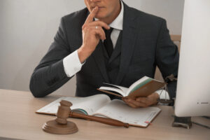 Business litigation attorney thinking about a case with books on his desk