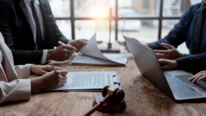 Lawyers reviewing and signing contract agreements during a legal meeting in an office.