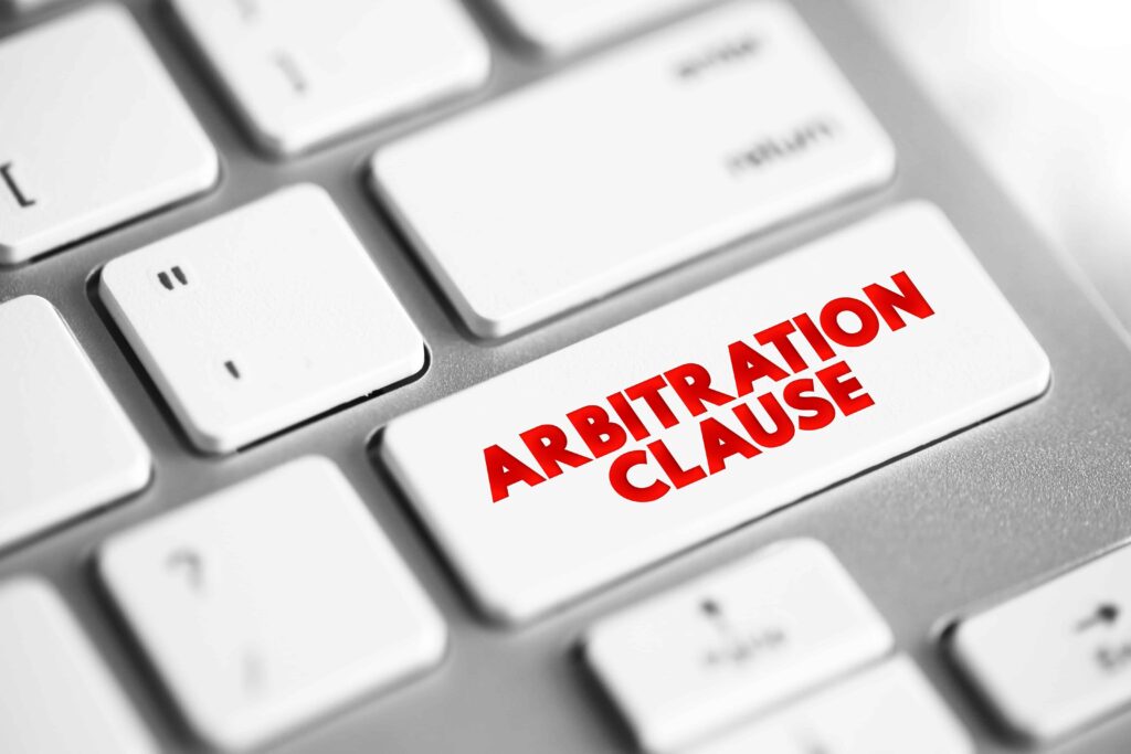 Keyboard key with words &lsquo;Arbitration Clause&rsquo; symbolizing legal contract terms and dispute resolution agreements.